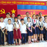 Đại diện chi nhánh NHCSXH tỉnh Bình Phước tặng quà và tuyên dương những em học sinh có thành tích học tập xuất sắc trong năm học 2008 - 2009