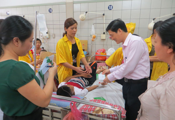 Đồng chí Đoàn Văn Khải (bên phải) - Chủ tịch Công đoàn NHCSXH trao quà cho các cháu thiếu nhi đang điều trị tại bệnh viện Bạch Mai
