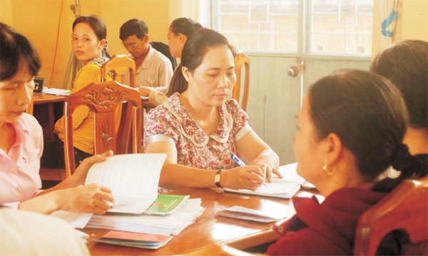 Chị Lê Thị Tuyết Mai (áo hoa) đang cùng các hội viên phụ nữ hoàn thiện thủ tục vay vốn NHCSXH
