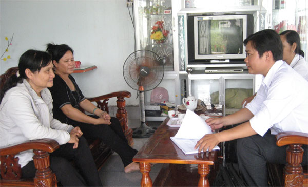Chị Phạm Thị Vân (ngoài cùng, bên trái) đang trao đổi công việc với cán bộ NHCSXH
