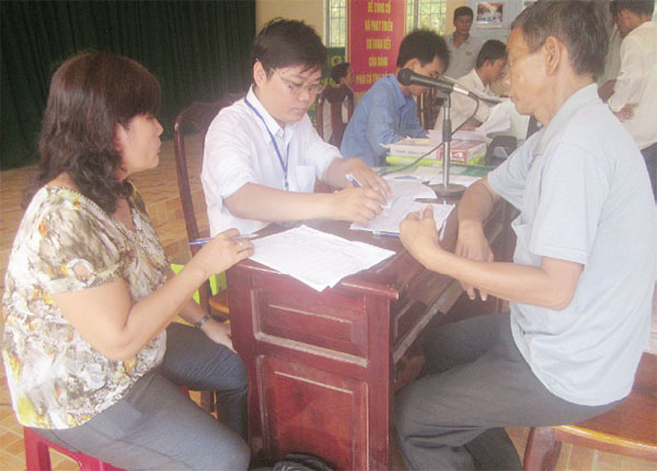 Nguyễn Nhựt Trường (áo trắng) đang hoàn thiện hồ sơ vay vốn cho bà con