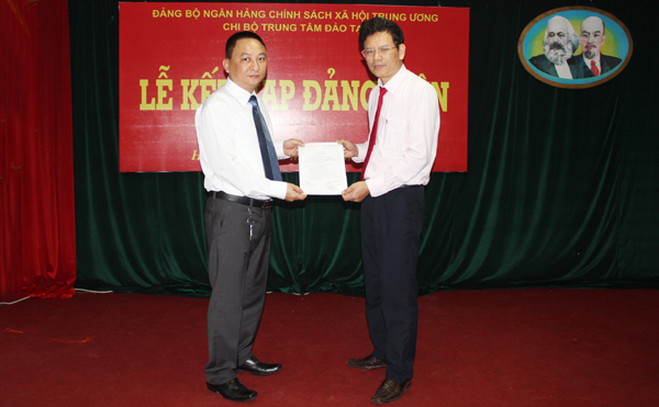 Đồng chí Trần Hữu Ý (trái) trao Quyết định kết nạp Đảng cho quần chúng ưu tú Vũ Hoàng Giang