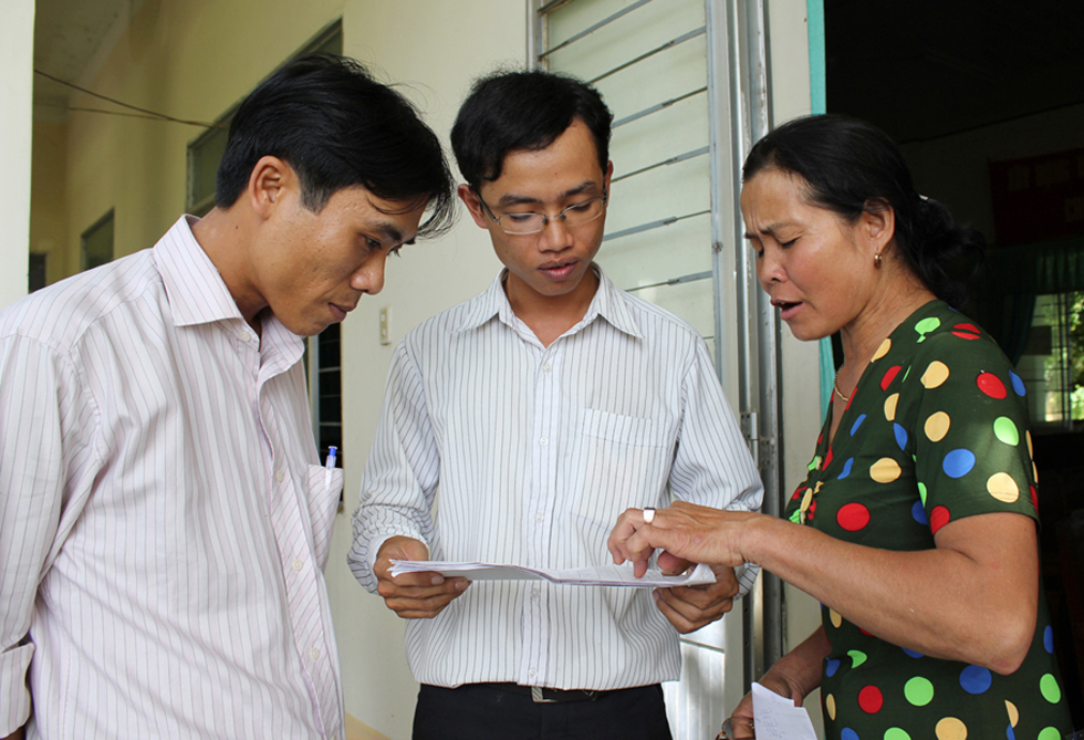 Cán bộ NHCSXH huyện Đồng Xuân, Trần Đình Bôn (giữa) đang giải thích cặn kẽ những thắc mắc của người dân trước khi vay vốn