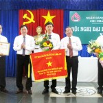 Đồng chí Dương Quyết Thắng (thứ 2, bên trái) và đồng chí Nguyễn Thuấn (thứ 2, bên phải) - Giám đốc NHCSXH chi nhánh tỉnh Long An trao Bằng khen, Cờ thi đua cho các tập thể và cá nhân đạt tích xuất sắc năm 2013