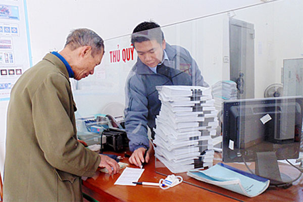 Cán bộ NHCSXH huyện Quỳnh Phụ đang hướng dẫn tận tình các khách hàng đến vay vốn