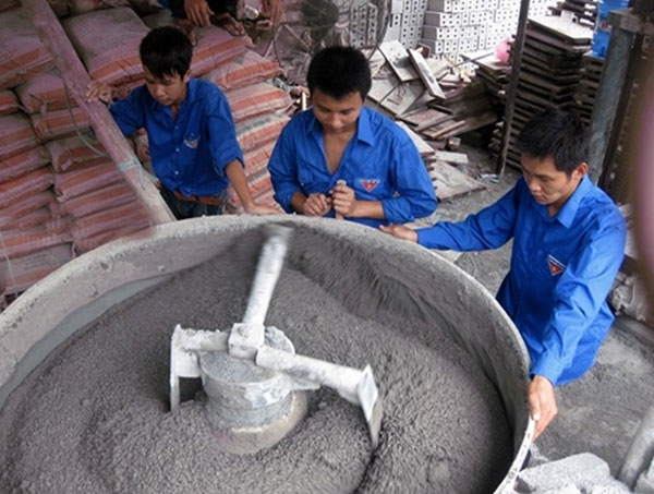 Châu Văn Chung (thứ 3 từ trái sang) với mô hình sản xuất gạch bloc không nung
