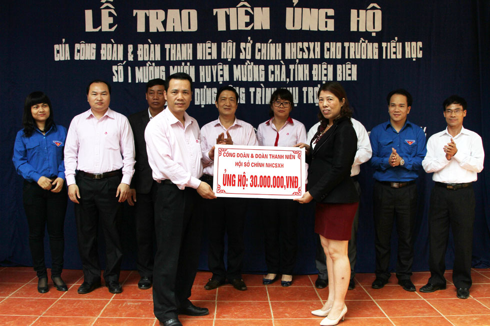 Phó Tổng Giám đốc NHCSXH Hoàng Minh Tế (hàng đầu, bên trái) trao số tiền ủng hộ kinh phí sửa chữa Trường tiểu học số 1 Mường Mươn