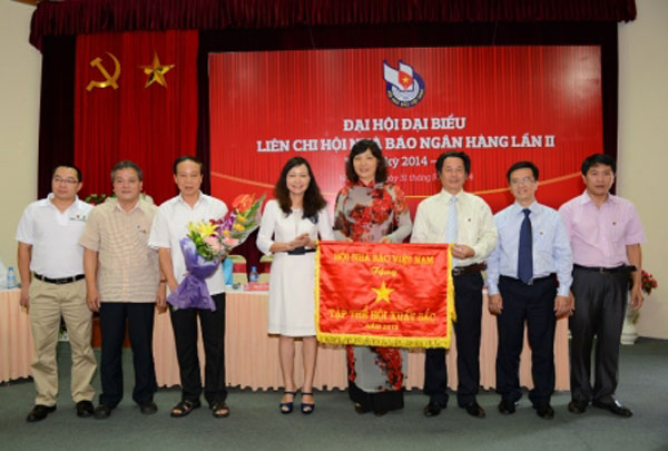 Bà Hà Kim Chi, Ủy viên BTV - Trưởng ban kiểm tra TW Hội nhà báo Việt Nam trao cờ thi đua cho tập thể xuất sắc