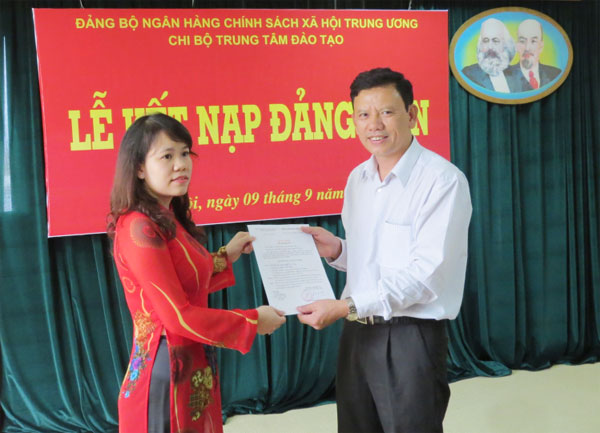 Đồng chí Trần Hữu Ý - Bí thư chi bộ Trung tâm Đào tạo trao Quyết định cho đảng viên mới Nguyễn Thị Tươi
