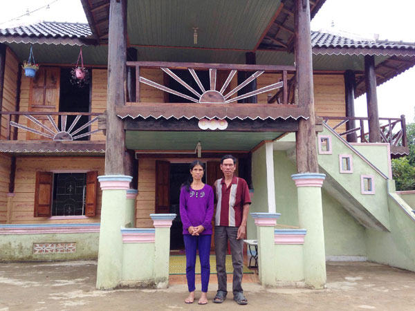 Vợ chồng ông Weo trước căn nhà khang trang