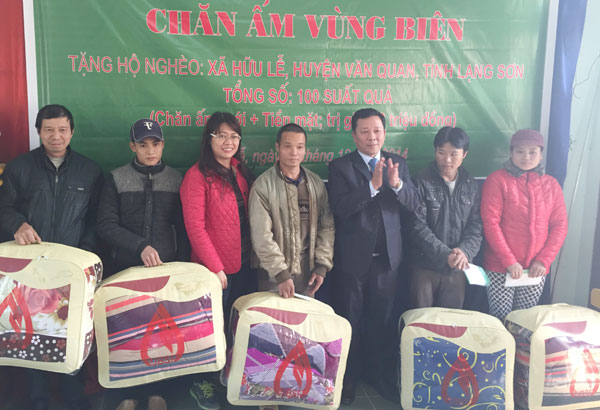 Phó Chủ tịch Công đoàn cơ sở Hội sở chính NHCSXH Phạm Hương Giang (thứ 3 trái qua) và Giám đốc NHCSXH tỉnh Lạng Sơn trao quà cho các hộ gia đình nghèo tại xã biên giới Hữu Lễ