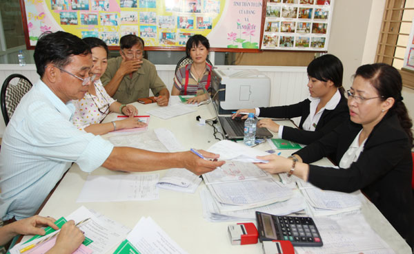 Chị Hiền (ngoài cùng bên phải) đang hướng dẫn khách hàng làm thủ tục vay vốn