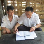Bí thư Đoàn xã Nông Văn Luận (bên phải) đang hướng dẫn hộ dân làm thủ tục vay vốn ưu đãi