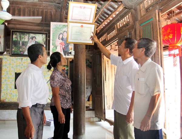 Vợ chồng anh Cao Văn Vát phấn (bên trái) tự hào giới thiệu tới lãnh đạo địa phương về thành tích học tập của các con