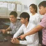 Dương Văn Chữ (áo kẻ) đang trao đổi cùng đồng nghiệp về nghiệp vụ kỹ thuật