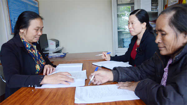 Chủ tịch Hội CCB xã Phù Lưu Phan Thị Tứ (trái) đang trao đổi nghiệp vụ với cán bộ NHCSXH và Tổ trưởng Tổ tiết kiệm và vay vốn