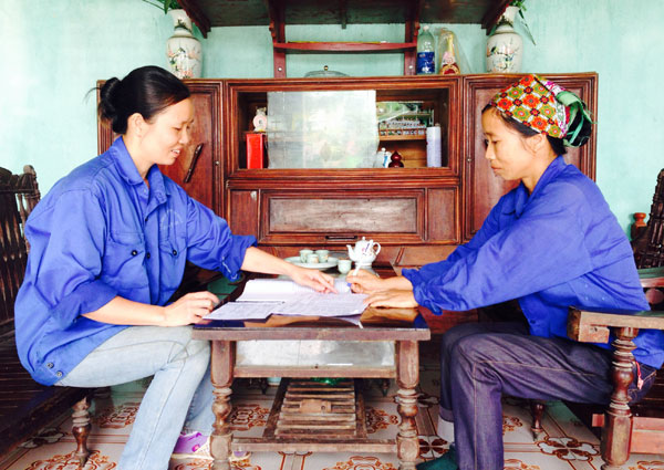 Chị Hoàng Thị Hà (trái) đang hướng dẫn thủ tục vay vốn cho tổ viên