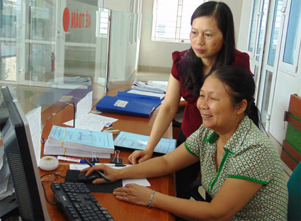 Chị Nguyễn Thị Nga (áo đỏ) trao đổi nghiệp vụ với kế toán viên