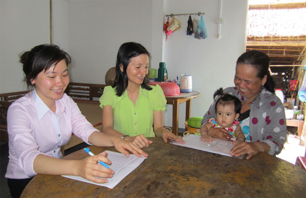 Chị Phạm Thị Kim Liên (giữa) cùng cán bộ ngân hàng kiểm tra hộ vay vốn