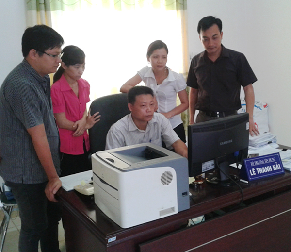 Anh Nguyễn Bình Nam (ngoài cùng bên phải) đang trao đổi nghiệp vụ với các đồng nghiệp trong đơn vị