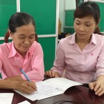 Bà Trần Thị Tạ (bên trái) cùng cán bộ NHCSXH trao đổi công tác quản lý nguồn vốn tín dụng trên địa bàn
