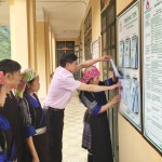 Giám đốc NHCSXH huyện Mù Cang Chải, Bùi Văn Hóa (áo hồng) đang giải đáp những thắc mắc về vay vốn chính sách cho bà con ở xã Dế Xu Phình