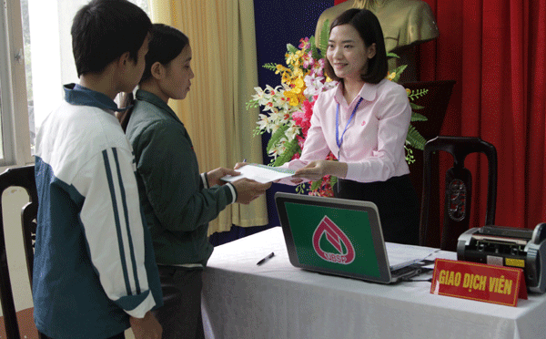 Các cán bộ của NHCSXH tỉnh Ninh Bình trao tiền ủng hộ của các nhà hảo tâm cho người giám hộ và các em nhỏ có hoàn cảnh khó khăn