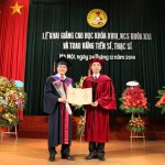 Giám đốc Học viện Ngân hàng (bên phải) trao Bằng và tặng hoa chúc mừng cho tân Tiến sĩ Dương Quyết Thắng