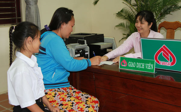 Cán bộ của NHCSXH tỉnh Cà Mau trao tiền ủng hộ của các nhà hảo tâm cho người giám hộ và các em nhỏ có hoàn cảnh khó khăn