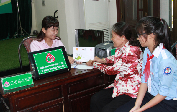 Cán bộ của NHCSXH tỉnh Thừa Thiên Huế làm thủ tục trao tiền ủng hộ của các nhà hảo tâm cho người giám hộ và các em nhỏ có hoàn cảnh khó khăn