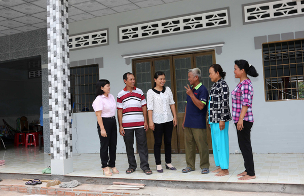 Niềm vui thoát nghèo ngập tràn trong căn nhà còn thơm mùi vữa của gia đình bà Kim Thị Tha (thứ hai từ phải qua)