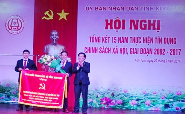 Phó Chủ tịch UBND tỉnh Lê Ngọc Tuấn trao bức trướng của BCH Đảng bộ tỉnh Kon Tum tặng NHCSXH tỉnh với dòng chữ “Đoàn kết, đổi mới, vì mục tiêu giảm nghèo và xây dựng nông thôn mới”