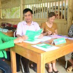 Cán bộ tín dụng Nguyễn Ngọc Sơn (thứ 2 từ trái sang) đang hướng dẫn bà con làm thủ tục vay vốn