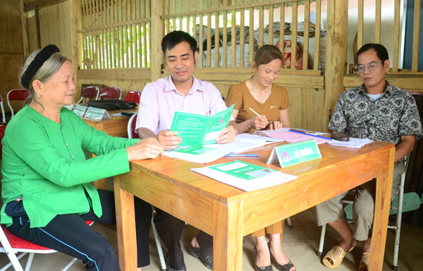Cán bộ tín dụng Nguyễn Ngọc Sơn (thứ 2 từ trái sang) đang hướng dẫn bà con làm thủ tục vay vốn
