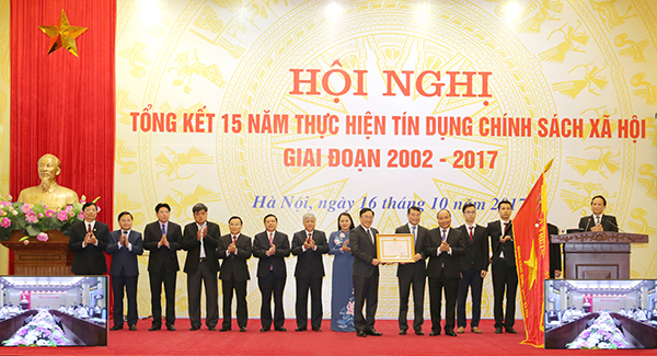 Đồng chí Nguyễn Xuân Phúc - Ủy viên Bộ Chính trị, Thủ tướng Chính phủ chúc mừng và trao Huân chương Lao động hạng Nhất cho NHCSXH