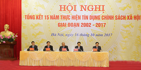 Đồng chí Nguyễn Xuân Phúc - Ủy viên Bộ Chính trị, Thủ tướng Chính phủ gắn Huân chương Lao động hạng Nhất lên lá cờ truyền thống của NHCSXH