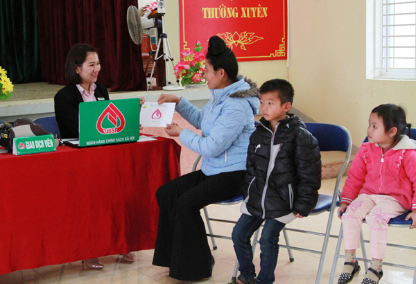 Cán bộ của NHCSXH tỉnh Sơn La làm thủ tục trao tiền ủng hộ của các nhà hảo tâm cho người giám hộ và các em nhỏ có hoàn cảnh khó khăn