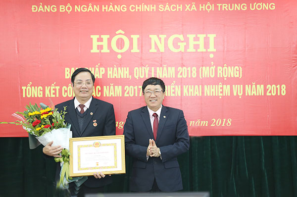 Đồng chí Dương Quyết Thắng - Bí thư Đảng ủy NHCSXH TW chúc mừng đồng chí Lê Ngọc Bảo nhận Huy hiệu 30 năm tuổi Đảng