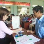 Cán bộ NHCSXH tỉnh Phú Yên đang giải thích cho người dân về lãi suất khi tham gia gửi tiền tiết kiệm tại Điểm giao dịch xã