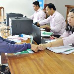 Cán bộ NHCSXH huyện Trần Văn Thời giao dịch với người dân