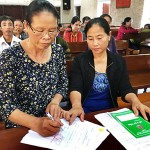 Chị Lê Thị Minh (bên trái) đang hướng dẫn hộ vay hoàn thiện thủ tục vay vốn