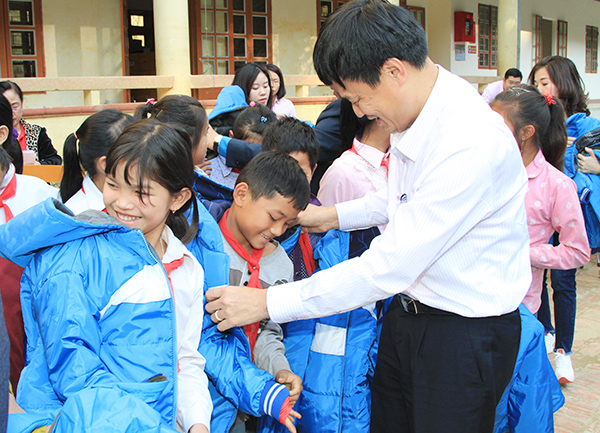 Phó Tổng Giám đốc NHCSXH Bùi Quang Vinh động viên các em học sinh Trường THCS Nà Ớt