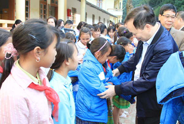 Phó Thống đốc NHNN, Chủ tịch Công đoàn Ngân hàng Việt Nam Đào Minh Tú trao tặng áo ấm cho các em học sinh Trường THCS Nà Ớt