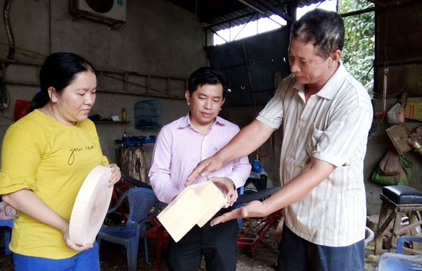 Ông Lê Mộng Long (bên phải) - Chủ cơ sở sản suất thớt gỗ ở phường Lái Thiêu phấn khởi vì có nguồn vốn vay ưu đãi để đầu tư phát triển sản xuất