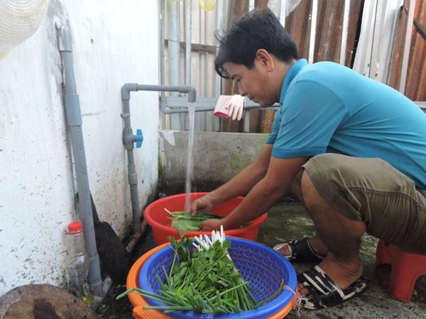 Anh Nguyễn Công Khanh ở khu vực Phú Tân vay vốn ưu đãi từ chương trình tín dụng NS&VSMTNT để xây bồn nước và lắp đặt hệ thống nước sạch phục vụ sinh hoạt