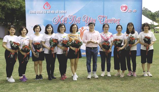 Tổng Giám đốc Dương Quyết Thắng tặng hoa cho đại diện lãnh đạo, cán bộ nữ NHCSXH và gửi lời chúc tới toàn thể chị em