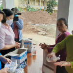 Cán bộ NHCSXH tỉnh Hà Nam phát khẩu trang và hướng dẫn khách hàng phòng chống dịch Covid-19