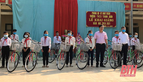 Đại diện Công đoàn cơ sở NHCSXH tỉnh Thanh Hóa tặng xe đạp cho các cháu học sinh có nhiều thành tích trong học tập của địa phương