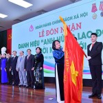Phó Chủ tịch nước Đặng Thị Ngọc Thịnh đính huy hiệu “Anh hùng lao động” thời kỳ đổi mới lên lá cờ truyền thống của NHCSXH