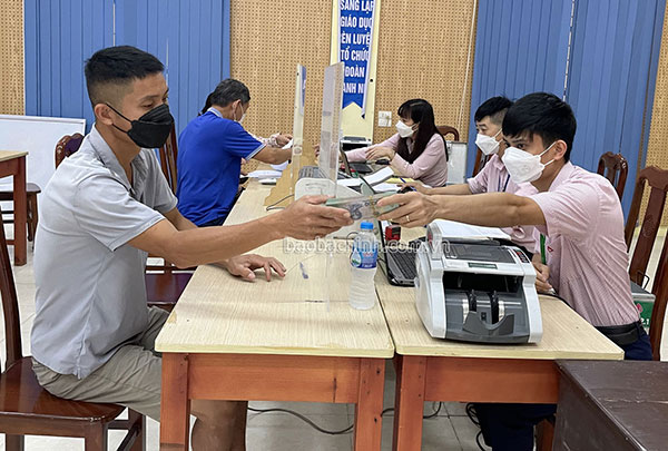 Cán bộ Phòng giao dịch NHCSXH huyện Quế Võ giải ngân cho vay theo Nghị quyết số 11 tại xã Yên Giả